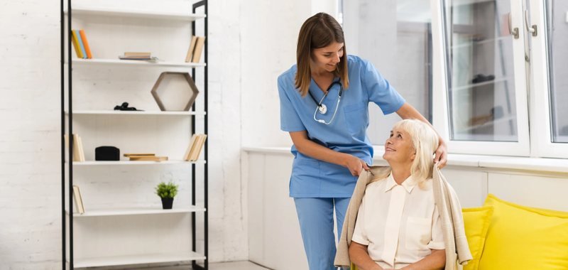 Caregiver assisting an elderly woman at home in Kuwait