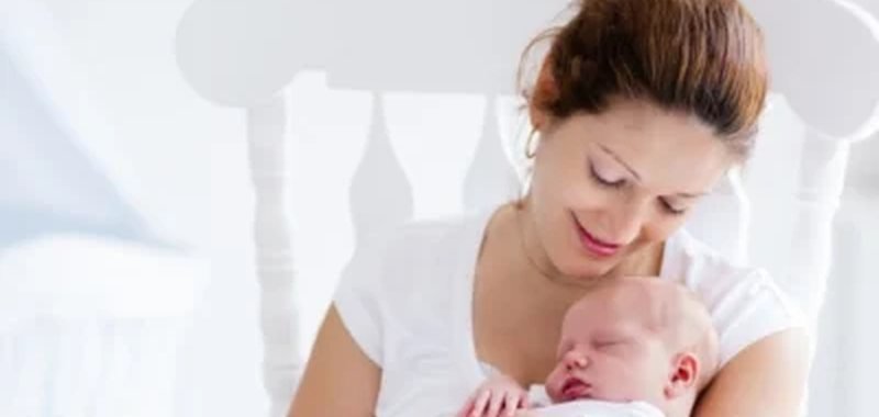 Caregiver holding a newborn baby for new born care in Kuwait