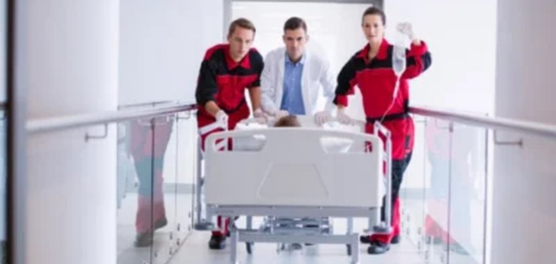 Medical team assisting a patient with in-home physiotherapy recovery
